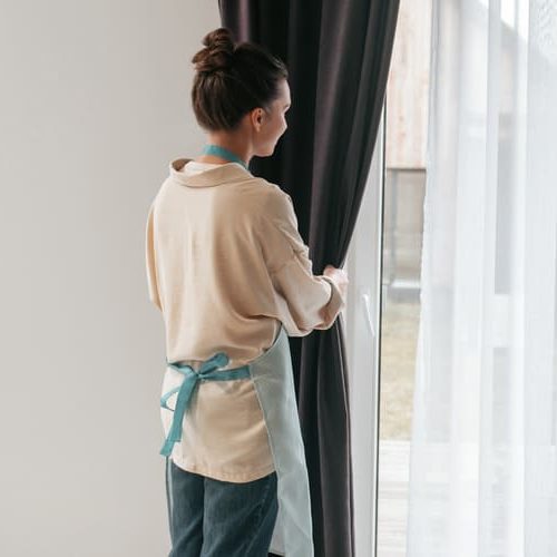 young-woman-standing-near-widnow-fixing-curtains (1) young-woman-standing-near-widnow-fixing-curtains (1)